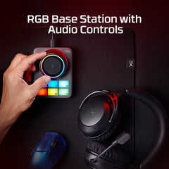 RGB base station with audio controls on a dark surface with gaming accessories.